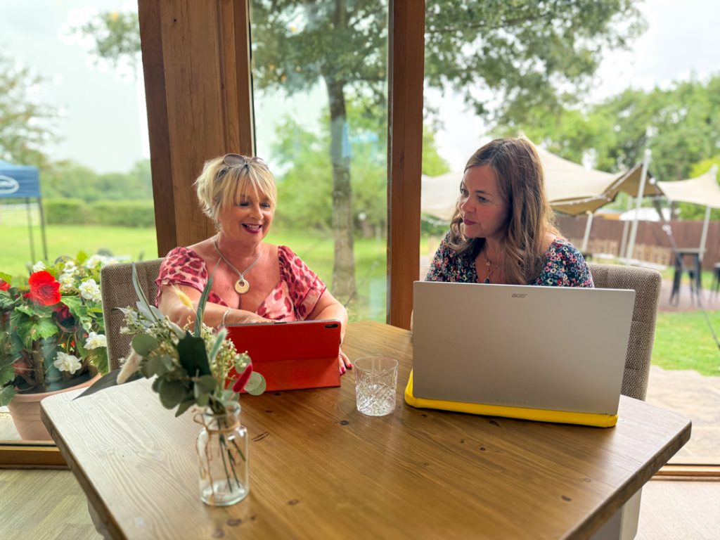 Jackie sitting with her tablet talking to a client on her laptop