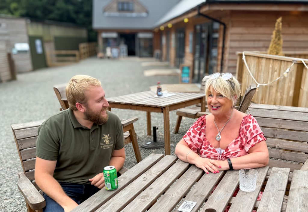 Jackie with a client at a wooden table outside